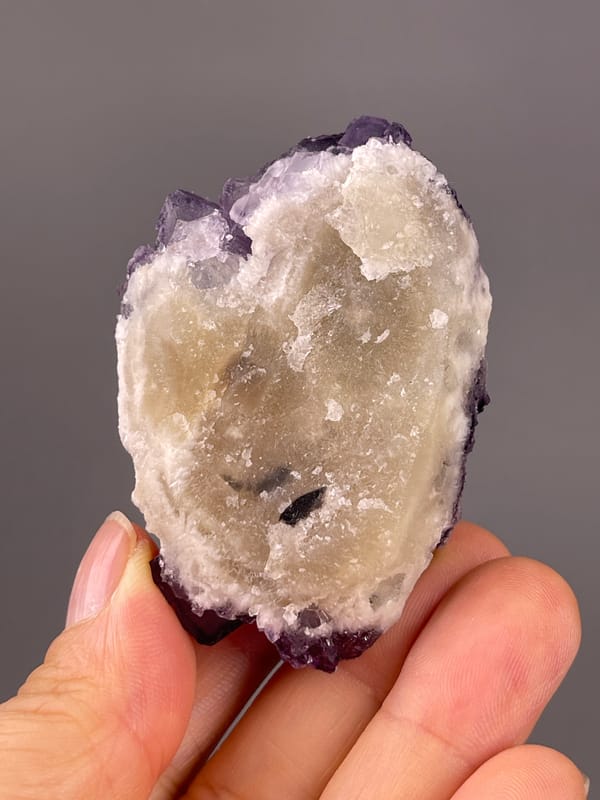 Calcite from Guizhou, China: pale reverse with a small dark inclusion and purple rim.