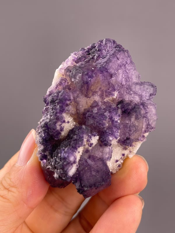 Calcite from Guizhou, China: vertical close view of the violet crystalline surface.