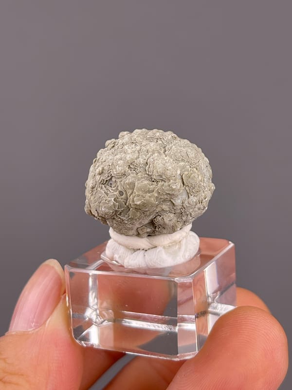 Calcite from Huanggangliang, Inner Mongolia, China: whole rounded cluster on its display base.