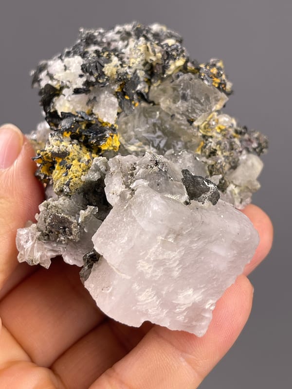 Calcite from Inner Mongolia, China: close view of pale faces beside dark and yellow patches.