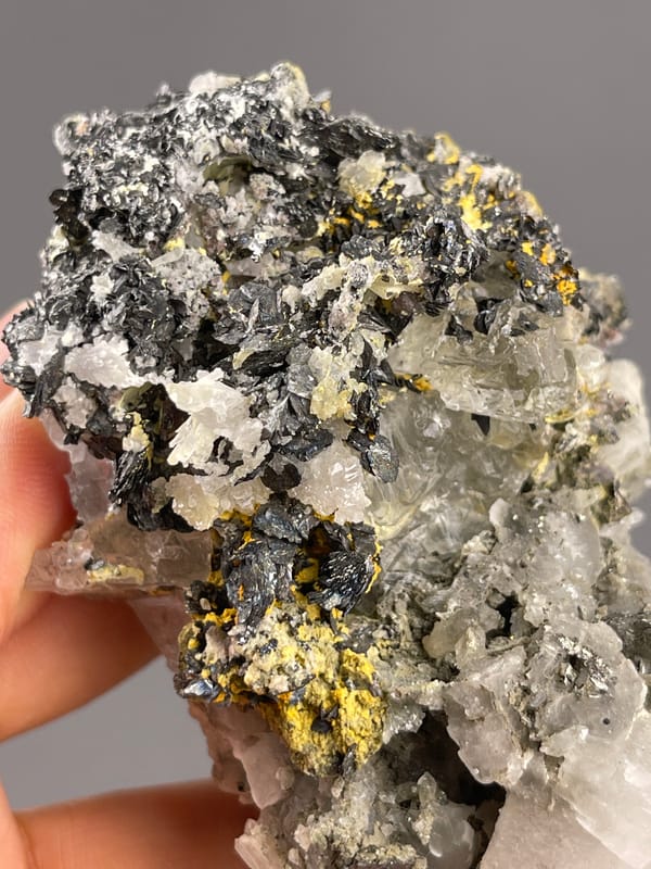 Calcite from Inner Mongolia, China: dark granular growths bordering translucent gray areas.