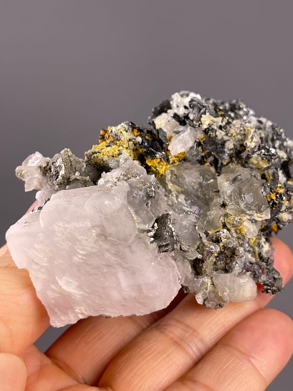 Calcite from Inner Mongolia, China: side view of the pale end crystal beside dark grains.