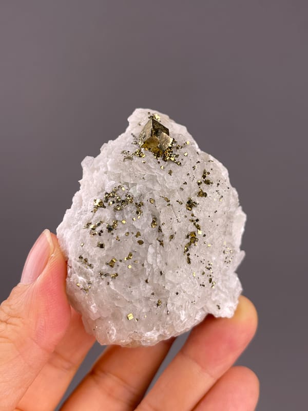 Calcite from Longyan, Fujian, China: pale pointed outline scattered with small metallic grains.
