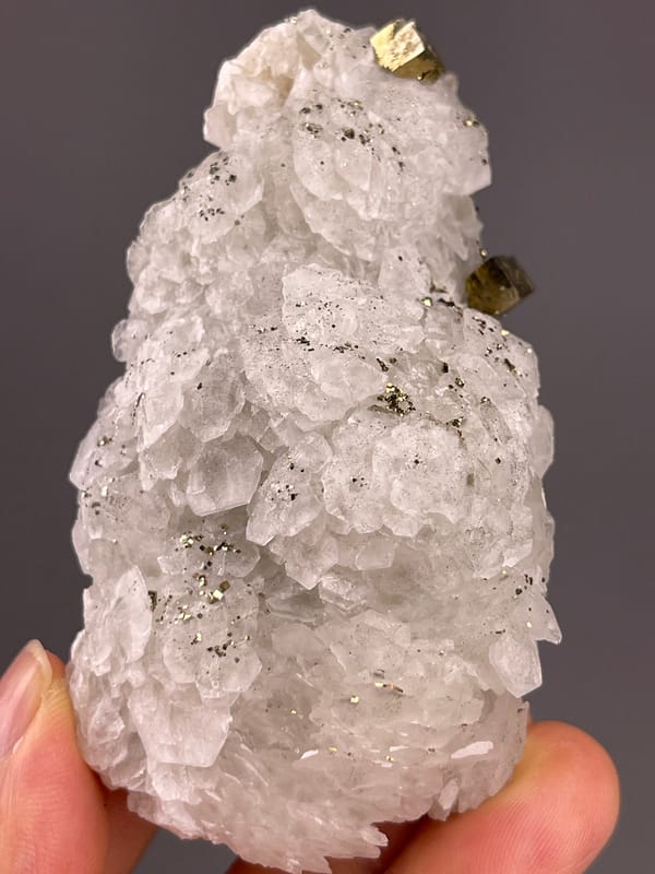 Calcite from Longyan, Fujian, China: front detail of overlapping pale growths and metallic accents.