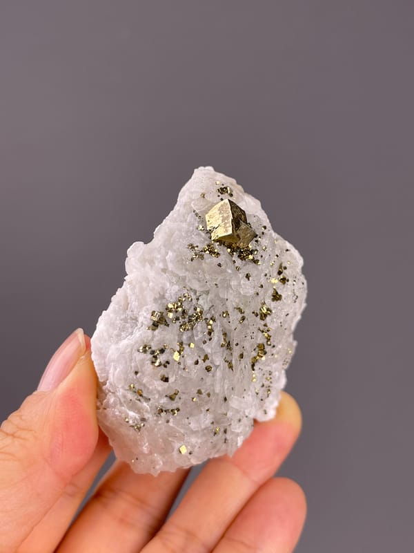 Calcite from Longyan, Fujian, China: tilted white face with bright brassy reflections.