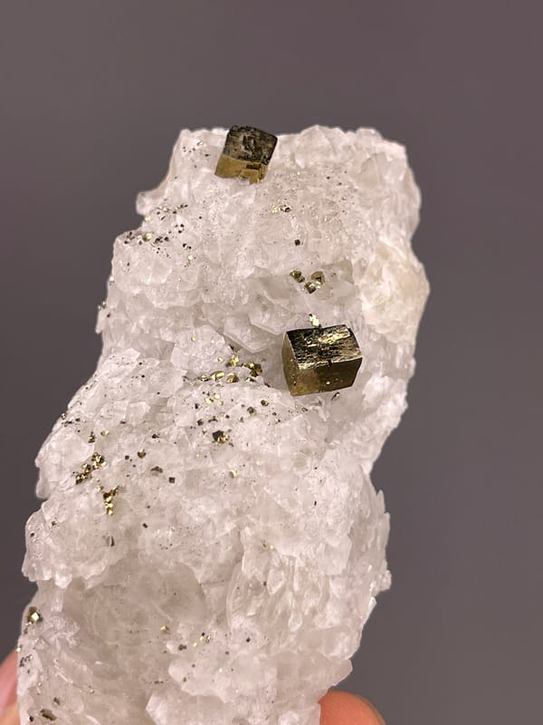 Calcite from Longyan, Fujian, China: close view of metallic blocks beside pale rounded layers.