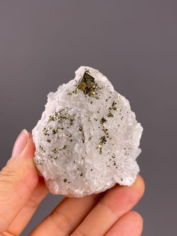 Calcite from Longyan, Fujian, China: whole pale specimen with sparse metallic accents.