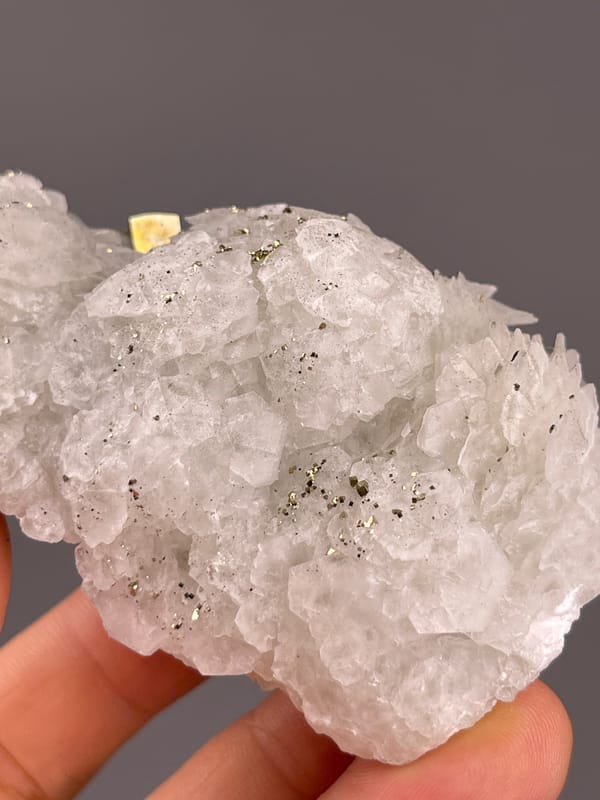 Calcite from Longyan, Fujian, China: detail of translucent pale growths and scattered dark specks.