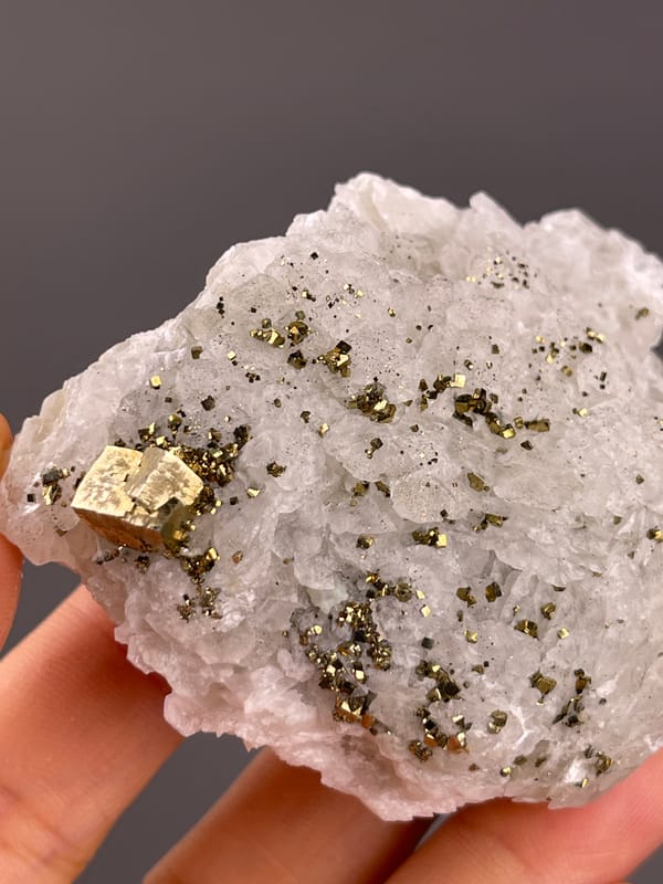 Calcite from Longyan, Fujian, China: bright flat metallic faces among small dark grains.