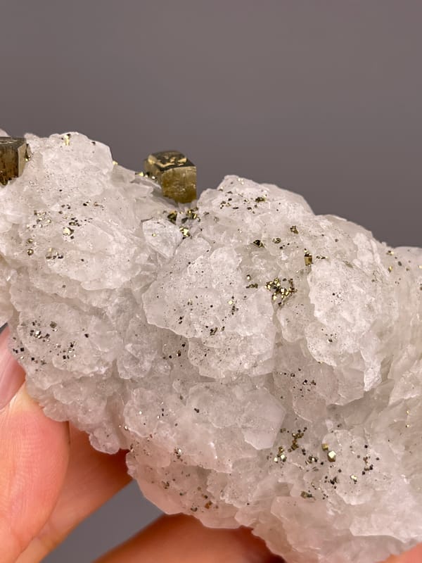 Calcite from Longyan, Fujian, China: close top angle of a brassy crystal among white layers.