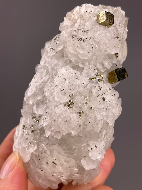 Calcite from Longyan, Fujian, China: front angle of layered white crystals and dark grains.