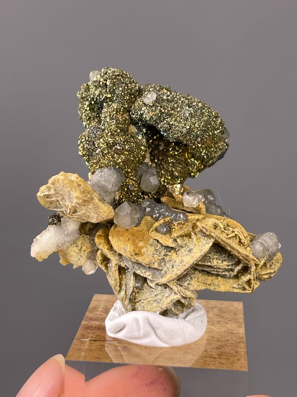 Calcite specimen from China featuring brassy masses above tan blades