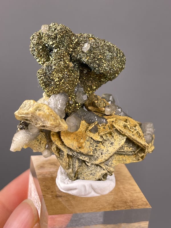 Calcite specimen from China, defined by brassy masses above tan blades