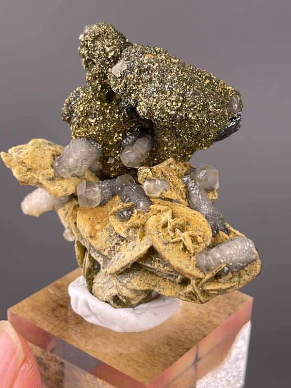 Calcite specimen from China presenting brassy masses above tan blades