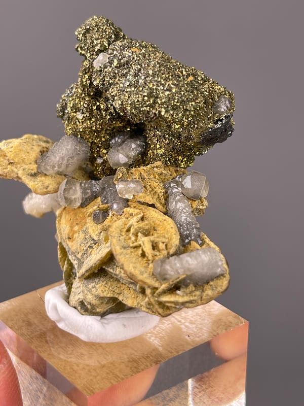 Brassy masses above tan blades visible on calcite specimen from China
