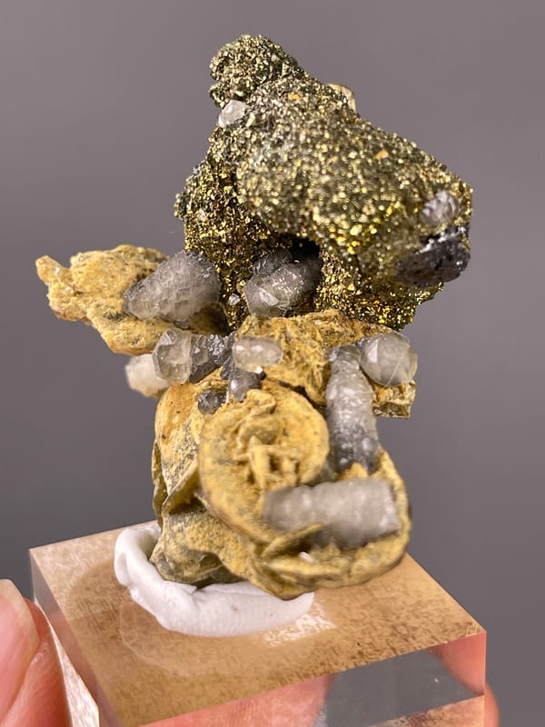 Calcite specimen from China displaying brassy masses above tan blades