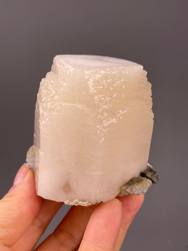 Off-white cleaved prismatic crystal visible on calcite specimen from Fujian, China