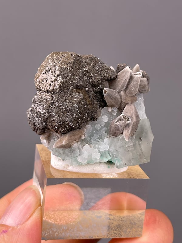 Calcite specimen from Longyan, Fujian, China showing dark globules with tan blades and green crystal