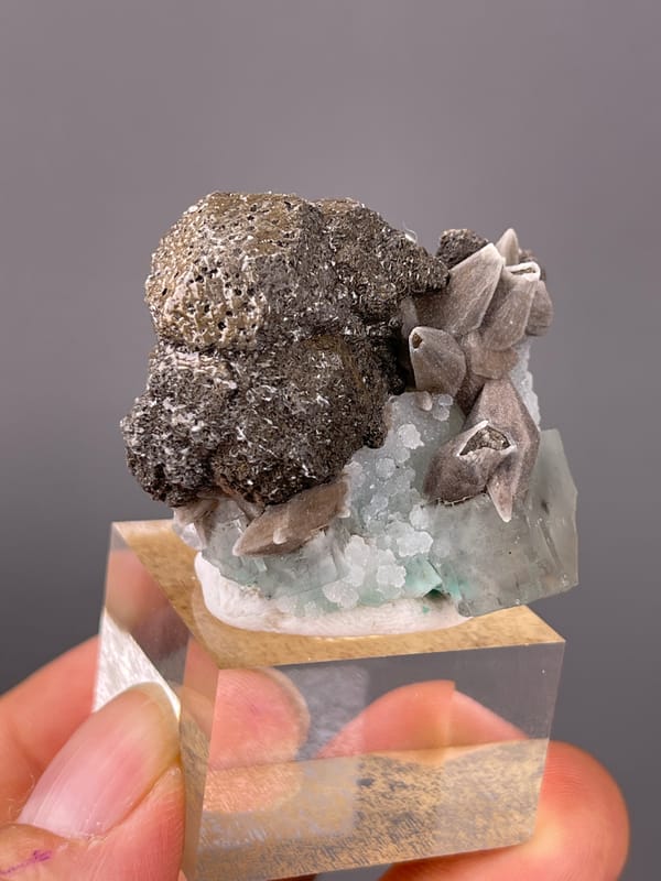 Calcite specimen from Longyan, Fujian, China, defined by dark globules with tan blades and green crystal
