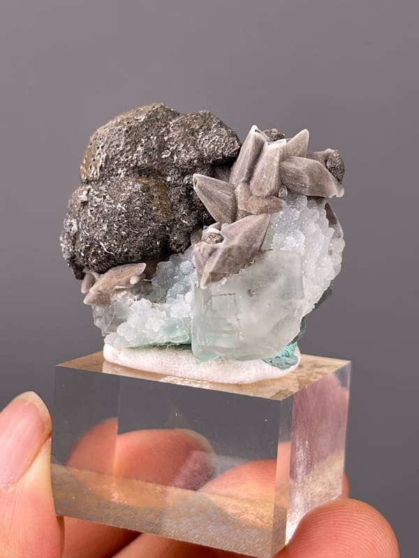 Calcite specimen from Longyan, Fujian, China presenting dark globules with tan blades and green crystal