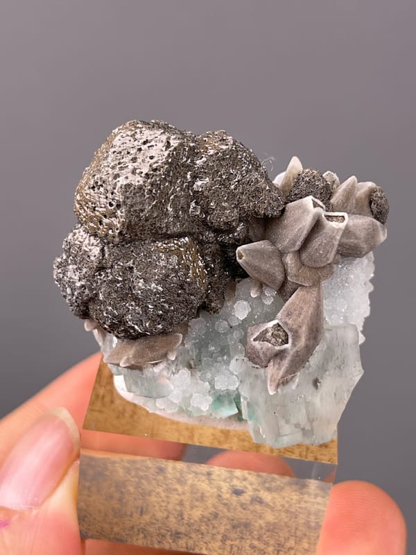 Calcite specimen from Longyan, Fujian, China displaying dark globules with tan blades and green crystal