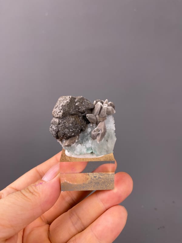 Calcite specimen from Longyan, Fujian, China highlighting dark globules with tan blades and green crystal