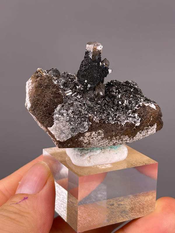 Calcite specimen from Longyan, Fujian, China displaying dark prismatic crystals with brassy coating