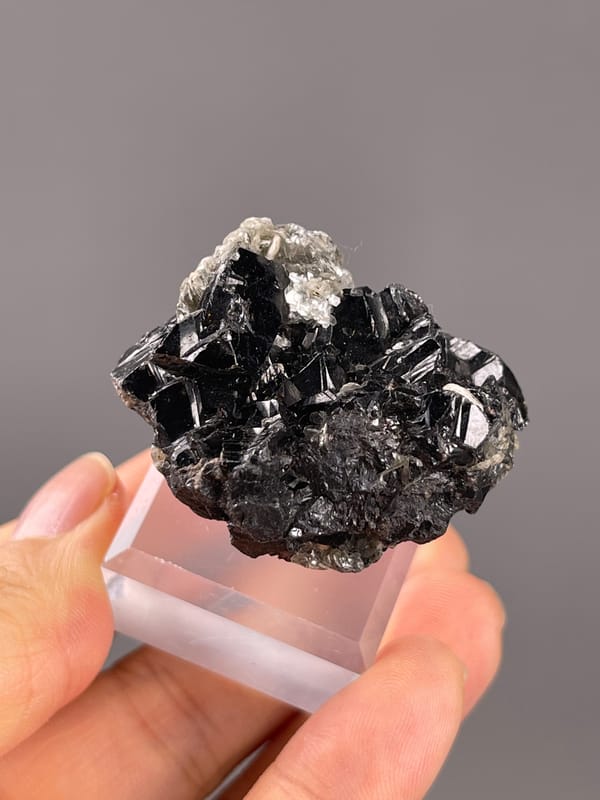 Cassiterite from Xuebaoding, China: angled black faces with silvery reflections.