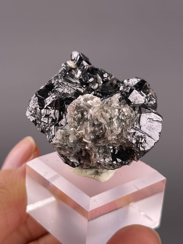 Cassiterite from Xuebaoding, China: mica-rich side with pale reflective sheets.
