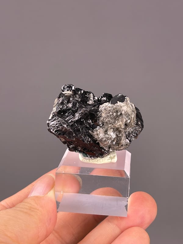 Cassiterite from Xuebaoding, China: whole black-and-silver cluster on its stand.