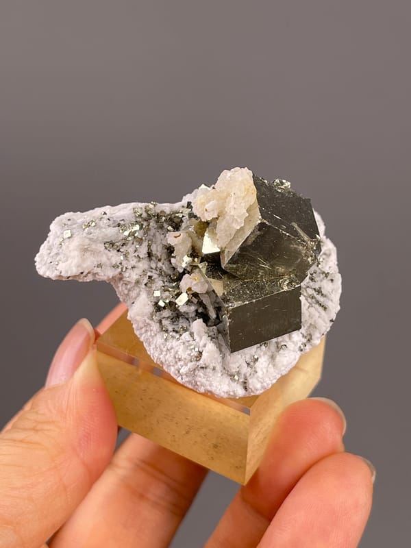 Chalcopyrite from Shangbao, Hunan, China: side view of a pale cap above dark metallic faces.