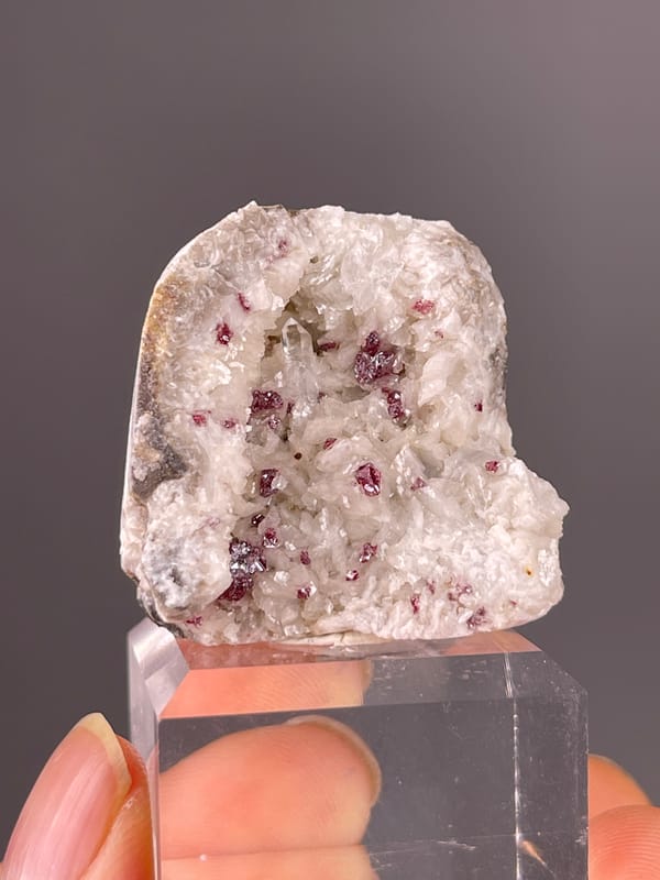 Reddish crystals in white matrix visible on cinnabar specimen from Hunan, China
