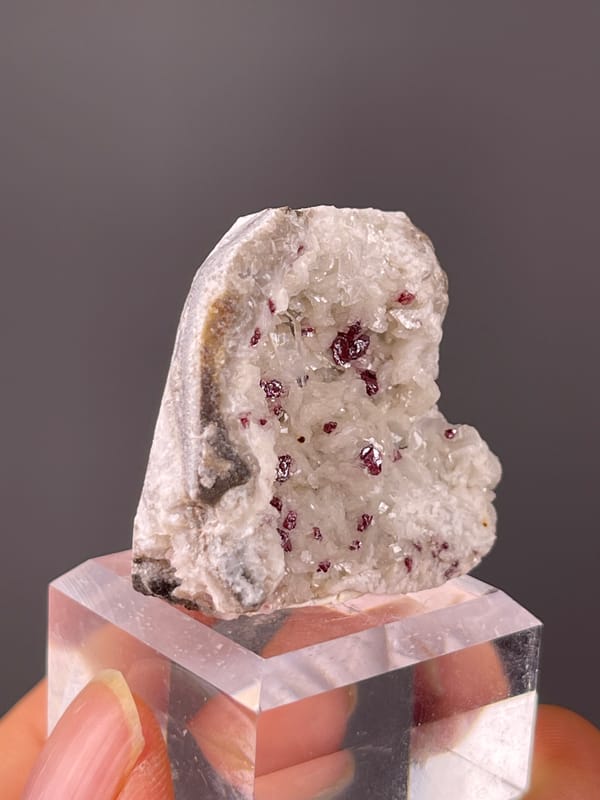 Reddish crystals in white matrix on natural cinnabar specimen from Hunan, China
