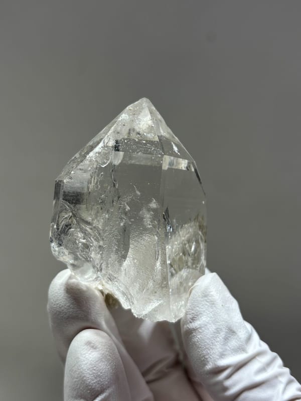 Clear quartz point with complete tip and mica from Xuebaoding, Sichuan, China, close-up of the crystal faces