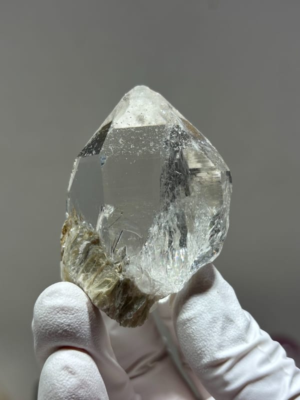 Clear quartz point with complete tip and mica from Xuebaoding, Sichuan, China, top view