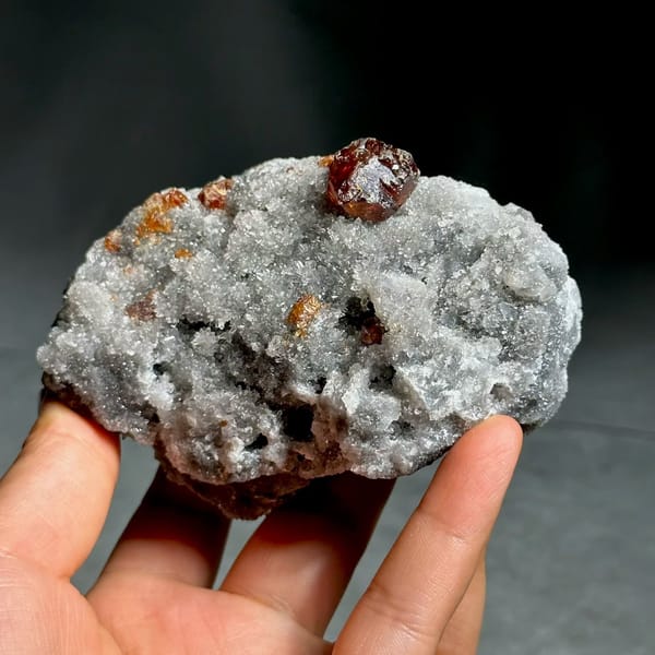 Single dark red sphalerite crystal on grey quartz druse from Hunan, China