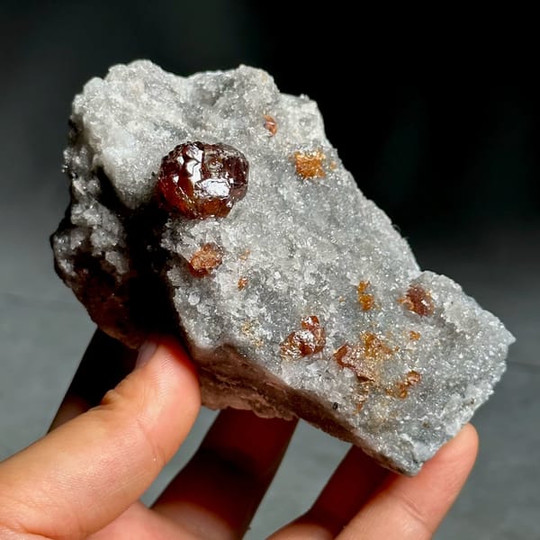 Single dark red sphalerite crystal on grey quartz druse from Hunan, China, view 2 of 13