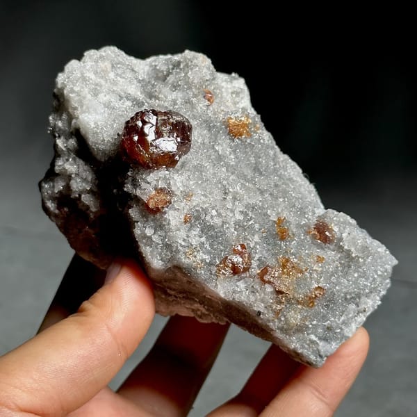 Single dark red sphalerite crystal on grey quartz druse from Hunan, China, view 9 of 13