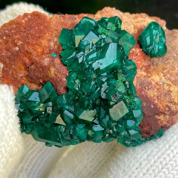 Emerald-green dioptase crystals on orange-brown matrix from Africa, view 5 of 9