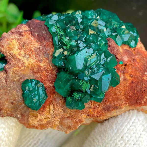 Emerald-green dioptase crystals on orange-brown matrix from Africa, view 8 of 9