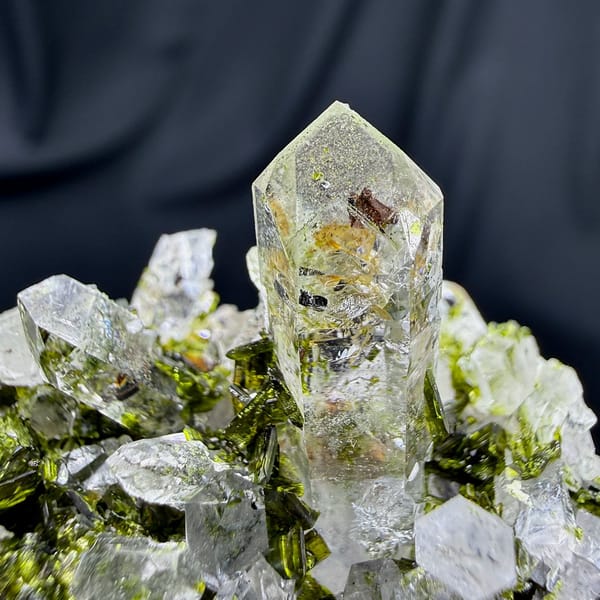 Clear quartz spire above green epidote cluster from Sichuan, China, view 5 of 6