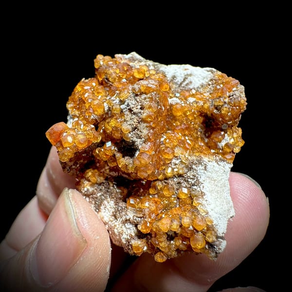 Fanta-orange spessartine garnet druse on grey feldspar from Yunxiao, Fujian, China, view 4 of 6