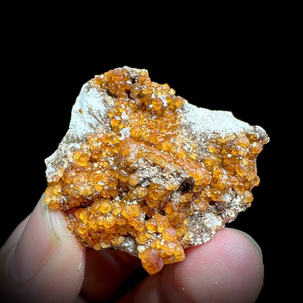 Fanta-orange spessartine garnet druse on grey feldspar from Yunxiao, Fujian, China, view 5 of 6
