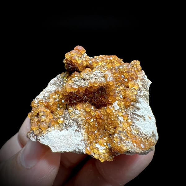 Fanta-orange spessartine garnet druse on grey feldspar from Yunxiao, Fujian, China, view 6 of 6
