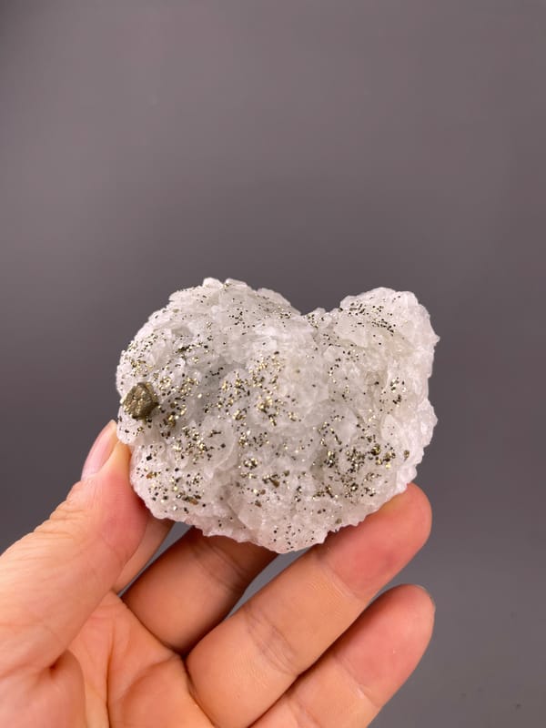 Fluorescent Petal-form Calcite specimen from Longyan, Fujian, China featuring white petal-form druse with pyrite