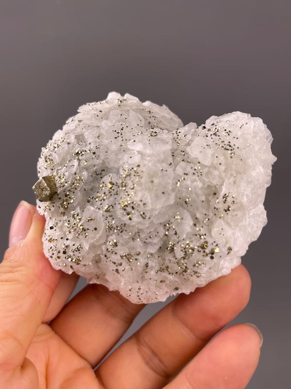 Fluorescent Petal-form Calcite specimen from Longyan, Fujian, China displaying white petal-form druse with pyrite