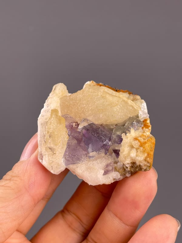 Fluorite from Fujian, China: broad purple face framed by pale calcite.