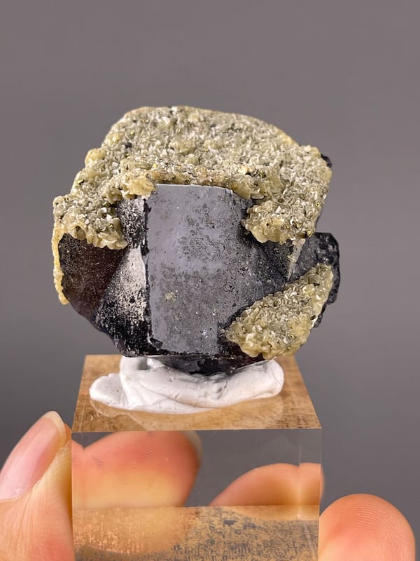 Fluorite from Fujian, China: broad dark face beneath a pale crystalline coating.
