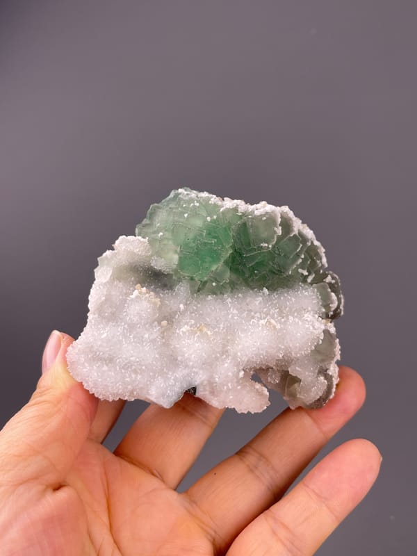 Fluorite from Fujian, China: front view of green crystals and granular quartz.