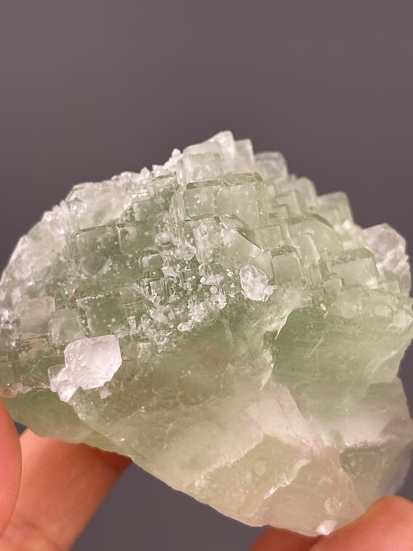 Fluorite from Fujian, China: translucent green faces with white surface patches.